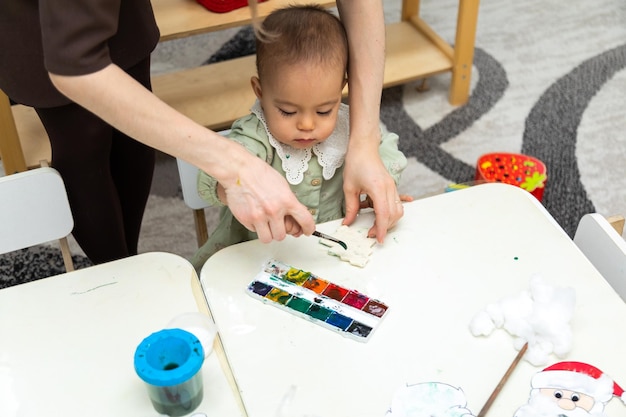 Bambino che dipinge un oggetto vuoto nell'asilo montessori