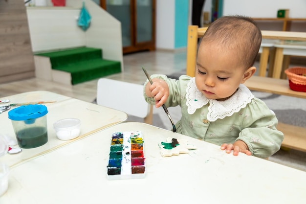 Bambino che dipinge un oggetto vuoto nell'asilo montessori