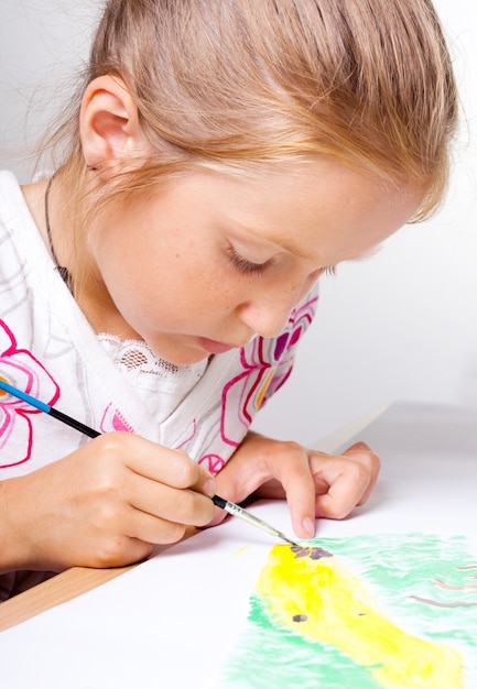 Bambino che disegna su uno sfondo bianco