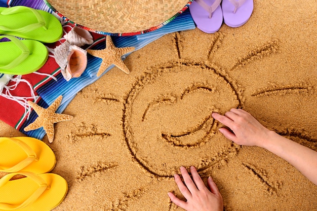 Bambino che disegna un sole sorridente su una spiaggia messicana