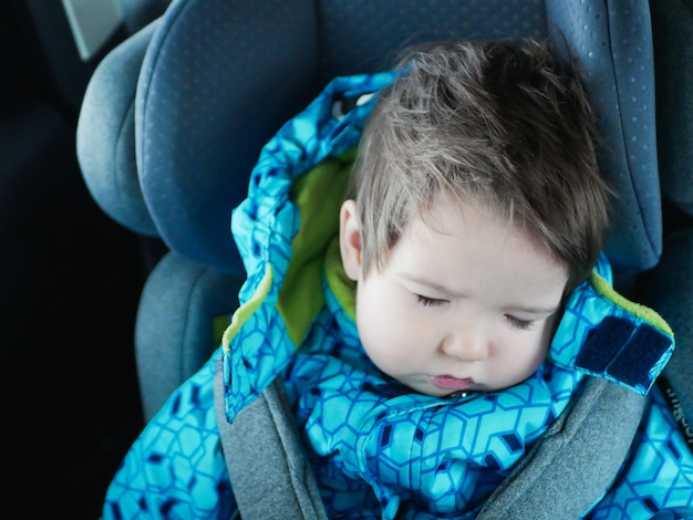 Bambino che dorme cavalca in un seggiolino per auto. Happy baby ride in a car. sicurezza dei bambini. Ragazzo sveglio che dorme in un'automobile nel seggiolino per bambini