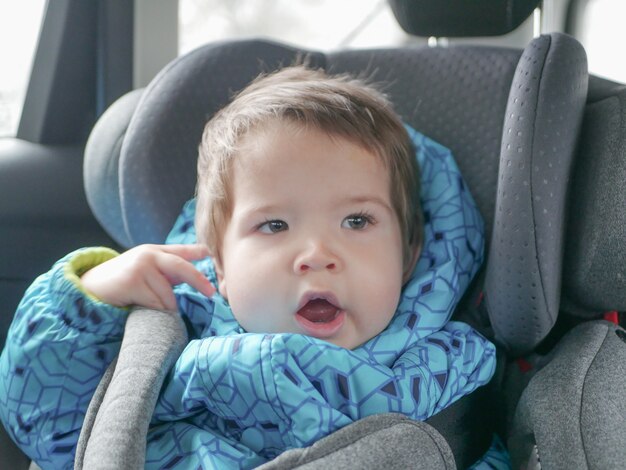 Bambino che dorme in un seggiolino per auto. Sicurezza dei bambini nel seggiolino durante il sonno.