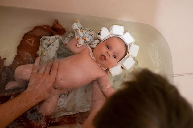 Bambino che fa il bagno indossando un cappello da nuoto speciale.