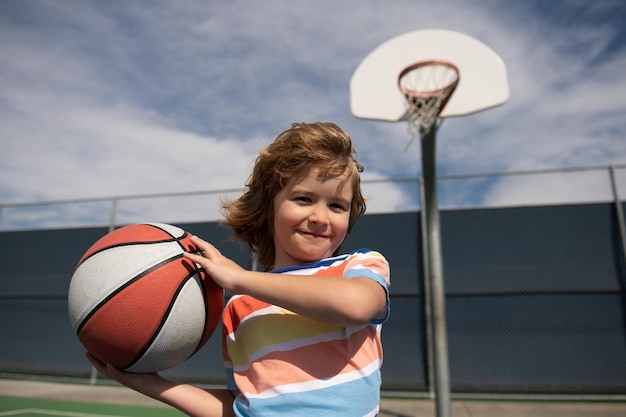 Bambino che gioca a basket con canestro Ritratto di bambino sportivo