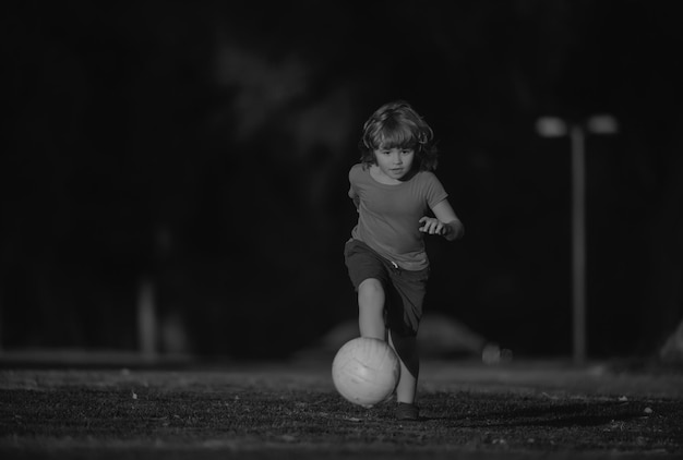 Bambino che gioca a calcio bambino felice che si diverte a giocare a calcio sportivo attività per bambini piccolo calciatore yo