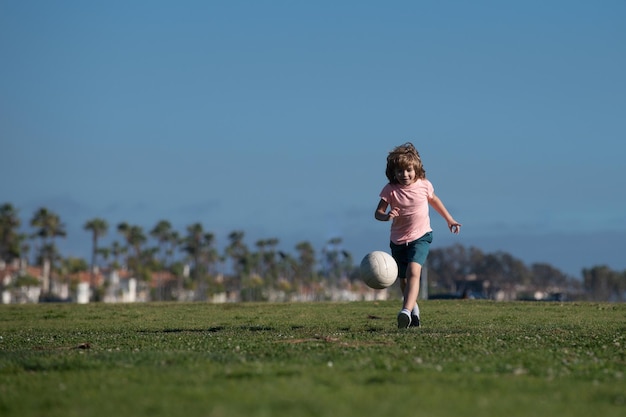 Bambino che gioca a calcio sul campo di calcio. Ragazzino che gioca a calcio. Bambini che allenano il calcio.