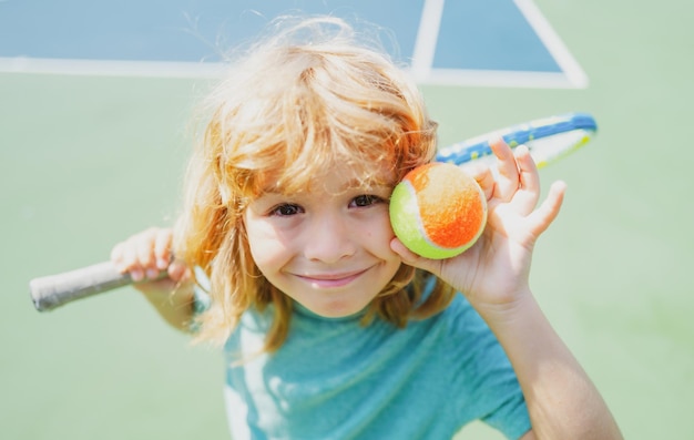 Bambino che gioca a tennis sul campo all'aperto bambina con racchetta da tennis e palla nello sport club attivo e