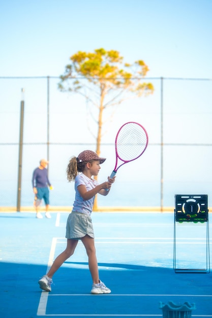 Bambino che gioca a tennis sul campo all'aperto