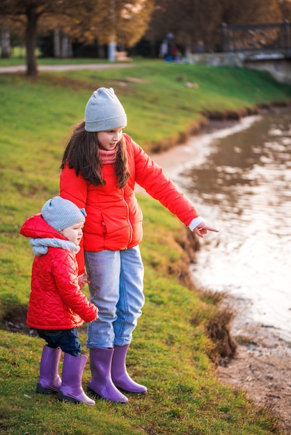 Bambino che gioca con barchette di carta in acqua di sorgente.lago o fiume.