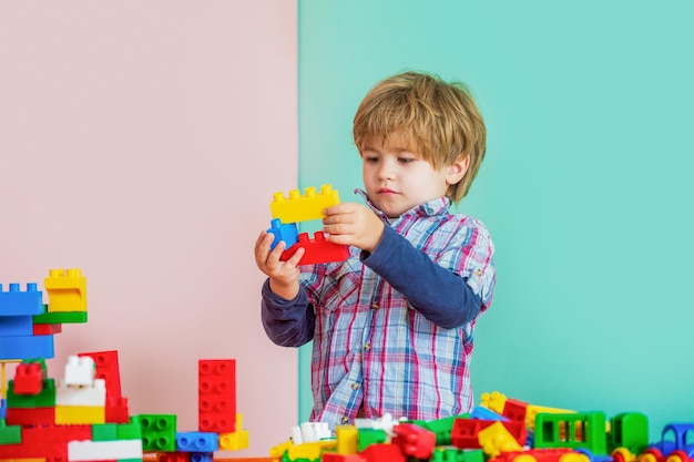 Bambino che gioca con blocchi colorati Giocattoli educativi per bambini Ragazzino che gioca con un sacco di blocchi colorati di plastica costruttore Ragazzo che gioca con blocchi di costruzione all'asilo