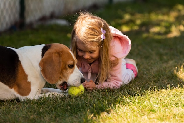 Bambino che gioca con il cane sull'erba