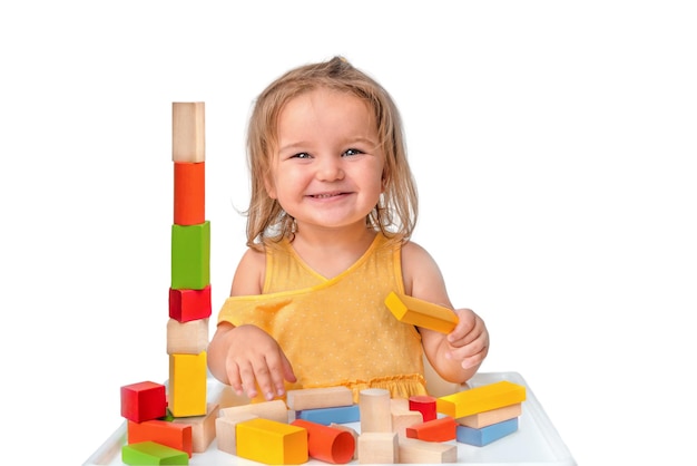Bambino che gioca con il costruttore di legno multicolore isolato su sfondo bianco