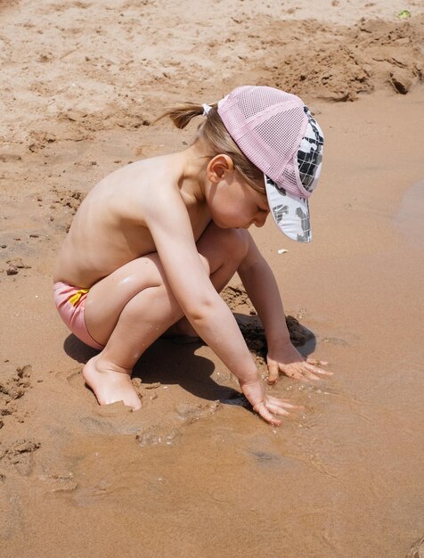 Bambino che gioca con la sabbia sulla spiaggia