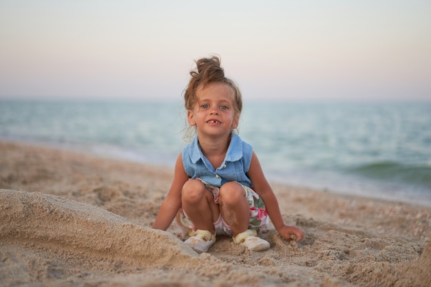 Bambino che gioca con la sabbia sulla spiaggia