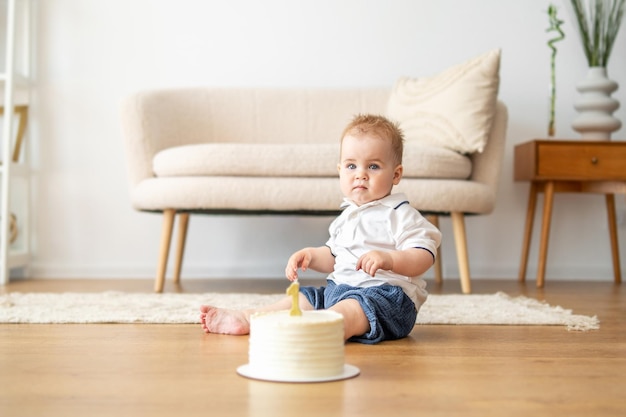 Bambino che gioca con la torta sul pavimento