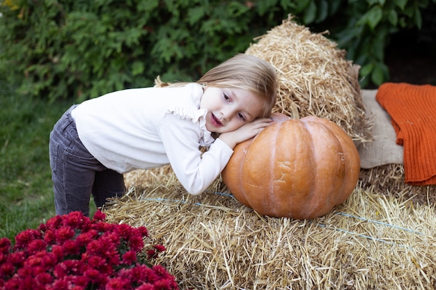 Bambino che gioca con la zucca in giardino