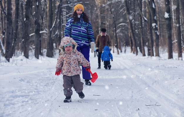 Bambino che gioca in un parco invernale e si diverte con la famiglia