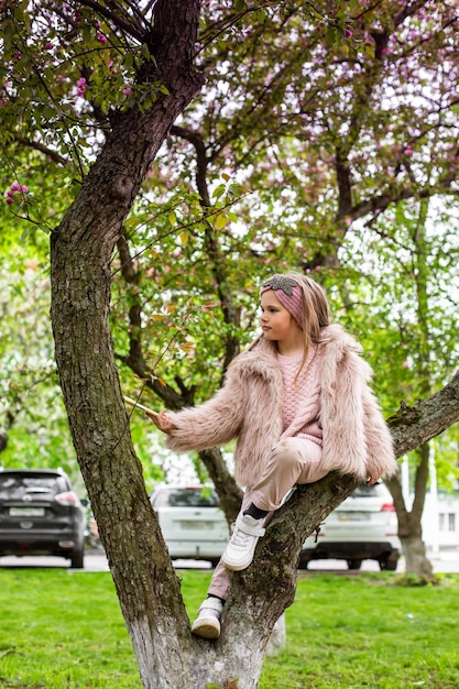 Bambino che gioca nel giardino che si arrampica sull'albero