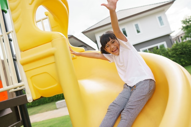 Bambino che gioca nel parco giochi all'aperto. I bambini giocano a scuola o nel cortile dell'asilo.