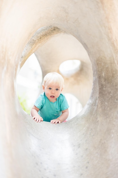 Bambino che gioca nel parco giochi all'aperto il bambino gioca a scuola o all'asilo bambino attivo sulla pietra