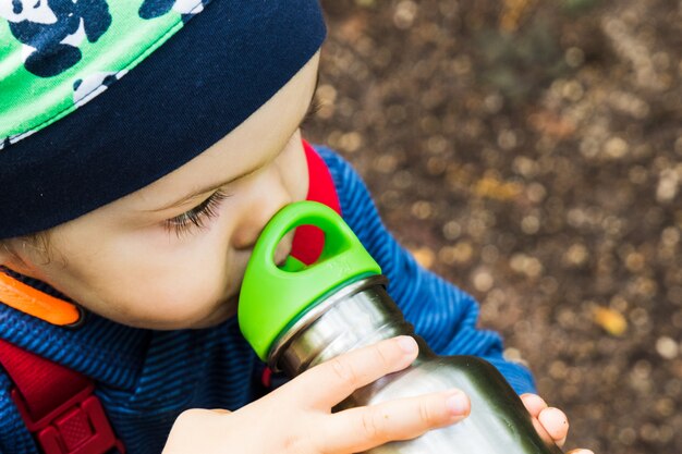 Bambino che gioca su un sentiero nel bosco in autunno