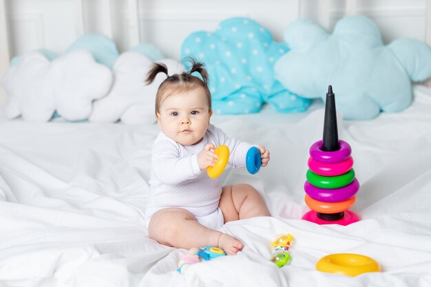 Bambino che gioca sul letto della piramide della casa, il concetto di una famiglia amorevole felice e lo sviluppo dei bambini