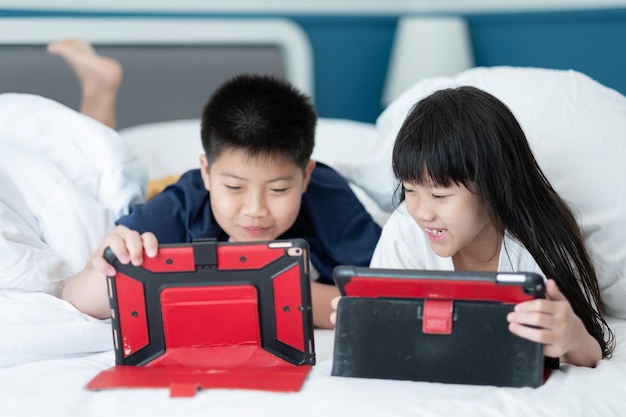 Bambino che guarda tablet sul letto cartone animato dipendente da bambini