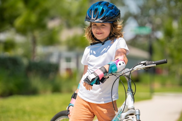 Bambino che guida una bicicletta nel parco estivo bambini che imparano a guidare una bicicletta su un vialetto fuori kid ri