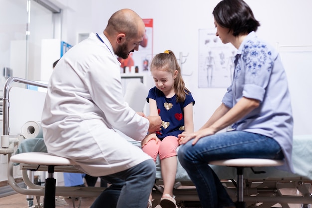 Bambino che ha dolore al braccio durante la visita medica nell'ufficio dell'ospedale. Medico sanitario specialista in medicina che fornisce consulenza sul trattamento dei servizi di assistenza sanitaria.