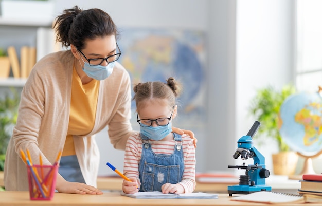 Bambino che indossa maschere per il viso che impara in classe