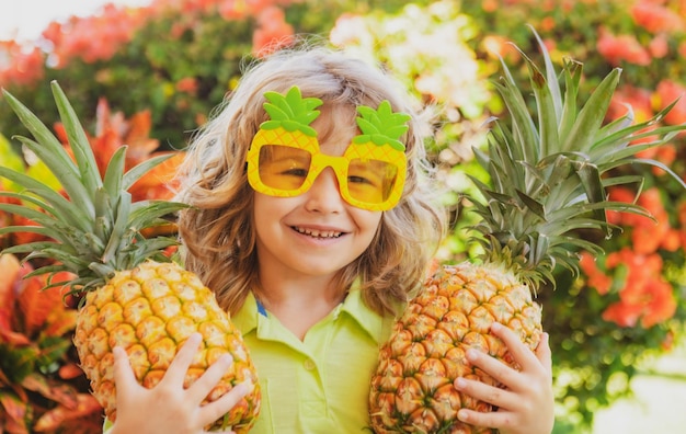 Bambino che indossa occhiali da sole divertenti con ananas Bambino con frutta tropicale Vacanza esotica Frutta per chil