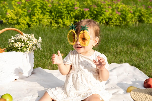 Bambino che indossa un paio di occhialini con sopra una corona di fiori.