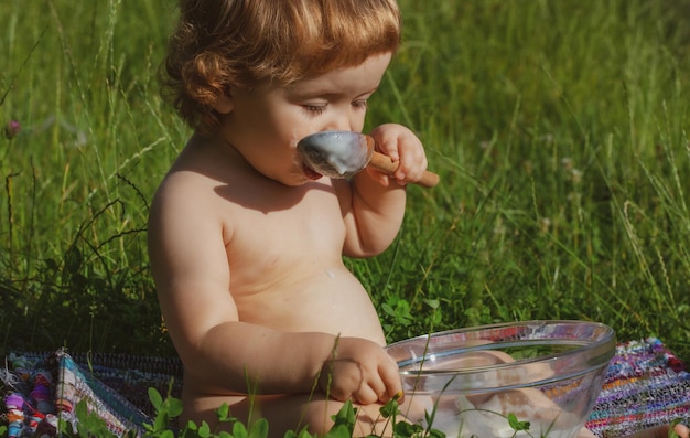 Bambino che mangia concetto di nutrizione cucchiaio che alimenta il bambino divertente faccia del bambino che alimenta il bambino con il cucchiaio grande outdo