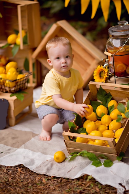 Bambino che mangia limoni e beve limonata all'aperto in estate al picnic