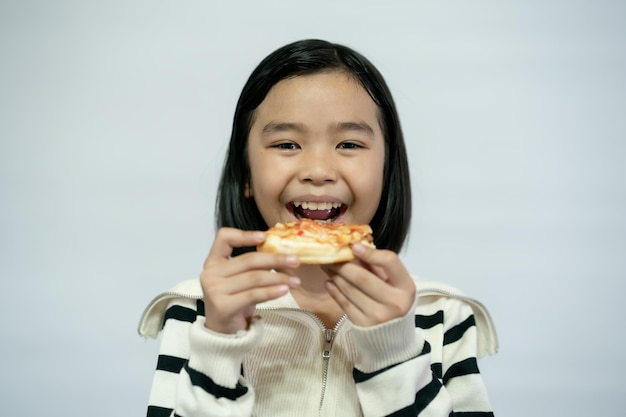 Bambino che mangia pizza su sfondo bianco