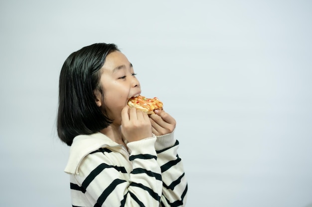 Bambino che mangia pizza su sfondo bianco