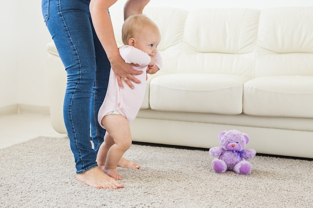 Bambino che muove i primi passi con l'aiuto della mamma a casa