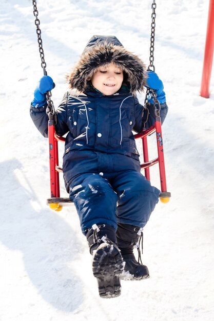 Bambino che oscilla nella neve