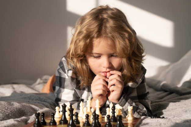 Bambino che pensa in modo intelligente ragazzino gioca a scacchi gioco di scacchi per bambini pensante per bambini intelligente intelligente e