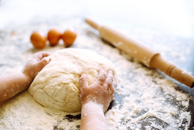 Bambino che prepara la pasta per la cottura. Piccole mani che impastano pasta e pasta arrotolata