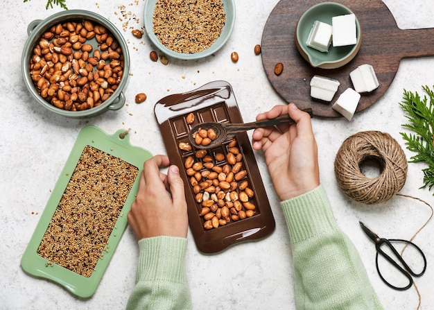 Bambino che riempie la forma della barretta di cioccolato con le arachidi. Concetto di educazione dei bambini.