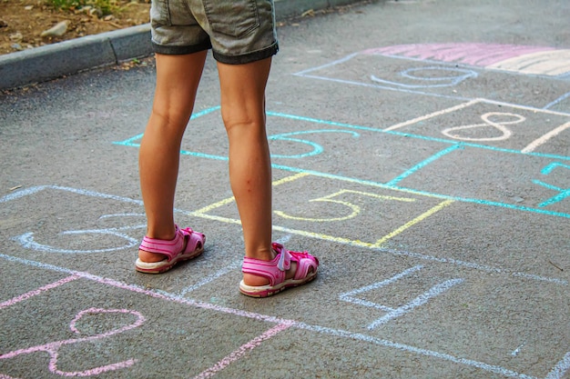 Bambino che salta classici sul marciapiede. Messa a fuoco selettiva.