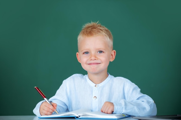 Bambino che scrive in classe Studente bambino che impara in classe studia la lingua inglese a scuola