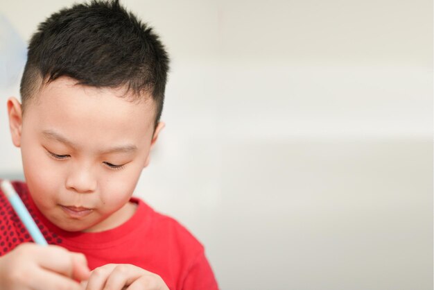 Bambino che scrive nel taccuino per la scuola