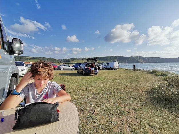 Bambino che si gode le vacanze dipingendo in mezzo alla natura in un campeggio in camper