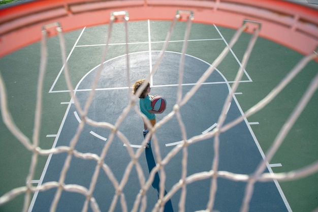 Bambino che si prepara per le riprese di basket all'aperto nel parco giochi