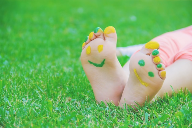 Bambino che si trova sull&#39;erba verde. Bambino divertendosi all&#39;aperto nel parco di primavera.