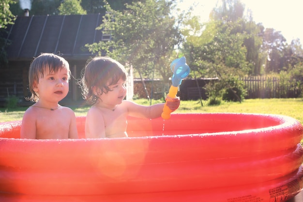 Bambino che spruzza nella vasca da bagno all'aperto