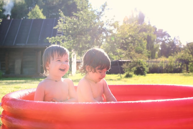 Bambino che spruzza nella vasca da bagno all'aperto