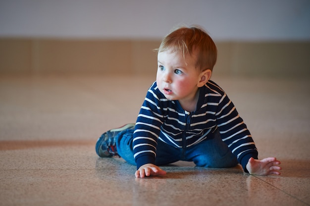 Bambino che striscia sul pavimento al centro commerciale